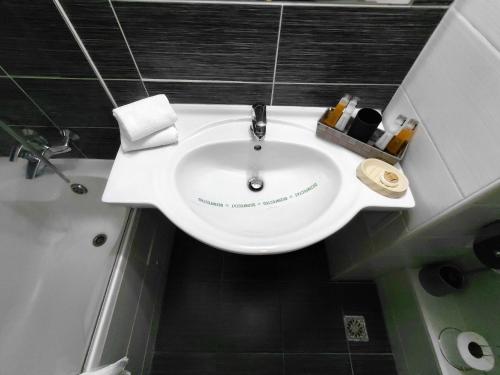 a bathroom with a white sink in a bathroom at Hotel Nord in Ploieşti