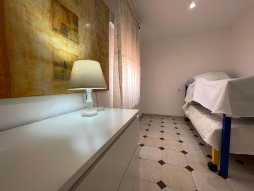 a bedroom with a bed and a lamp on a table at Apartamento CASA EL MORABITO in Puente Genil