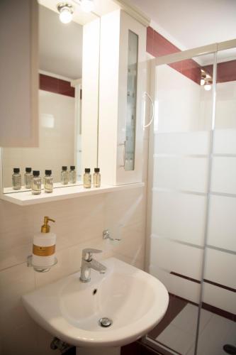 a white bathroom with a sink and a mirror at Irida Suite in Salamina