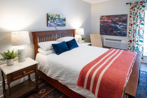 a bedroom with a large bed with blue pillows at The Cove Inn in Westport