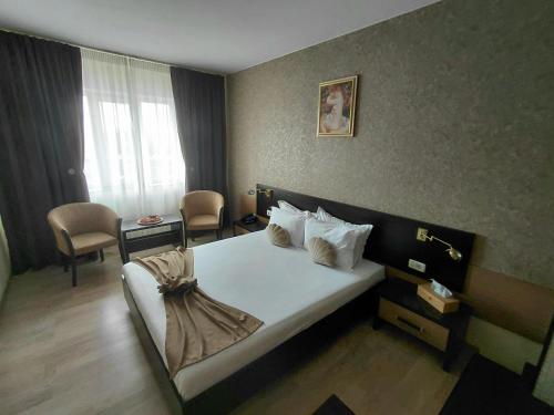 a hotel room with a bed and a desk at Hotel Nord in Ploieşti