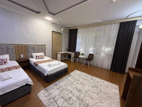 a hotel room with two beds and a table at Anor Avenue Hotel in Tashkent