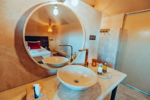 a bathroom with two sinks and a large mirror at Kidal Luxury Camp in Adrouine