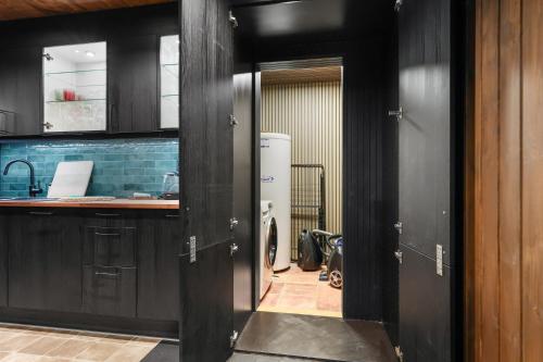 a kitchen with black cabinets and a refrigerator in a room at Cozy Mountain Beito - 18 sengeplasser - bilijard in Beitostøl