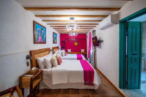 a bedroom with a white bed with pink walls at Casa Moseua Hotel Boutique de Autor in Querétaro