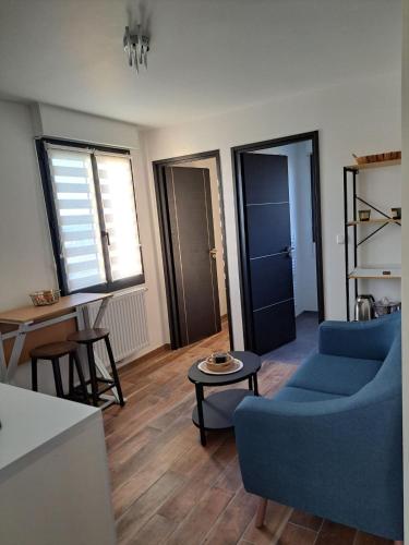 a living room with a blue couch and a table at Chez Cess in Chouilly