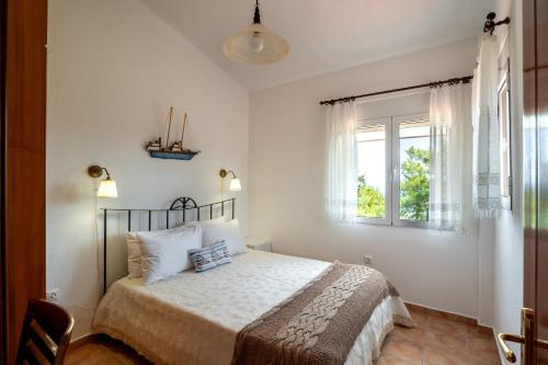a bedroom with a bed and a window at THEA MARE villa in Nea Potidaea