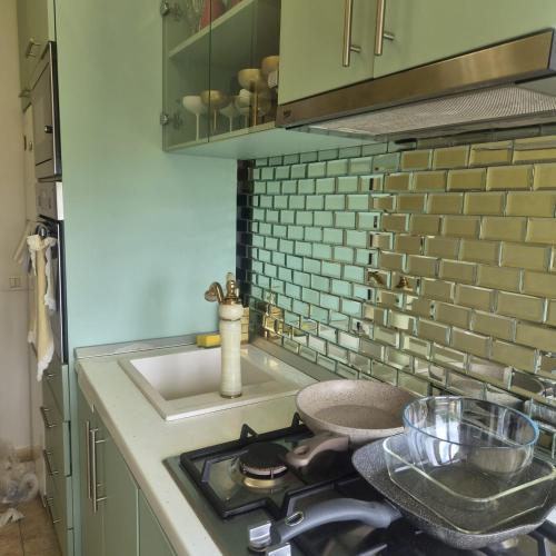 a kitchen with a stove top oven next to a sink at Apartament Stephen in Constanţa