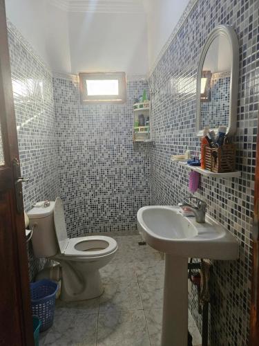 a bathroom with a toilet and a sink at Villa route ourzazate in Aït Ourir