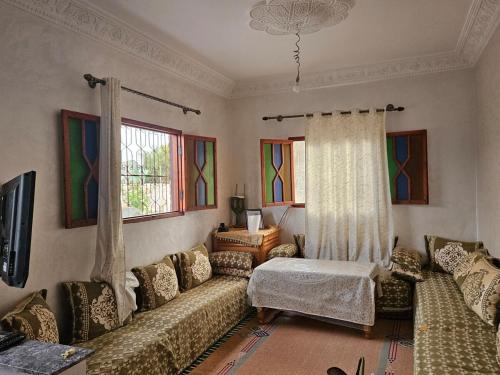 a living room with two couches and a window at Villa route ourzazate in Aït Ourir