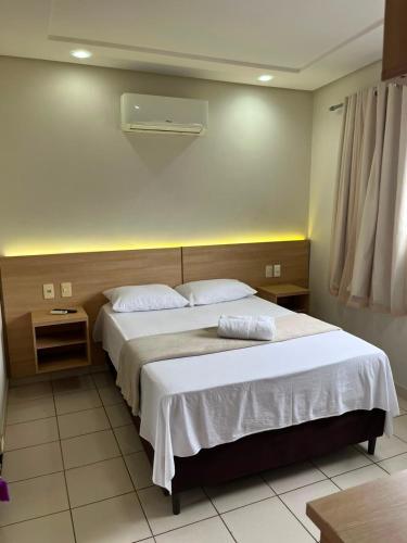 a bedroom with a large bed with white sheets at Hotel Piracema Caruaru in Caruaru