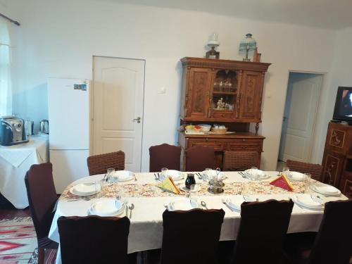 a dining room with a table with chairs and a cabinet at Sófalvi Vendégház in Sîntimbru