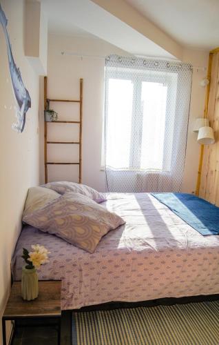 a bedroom with a bed with a window and a table at La Playa - 5 couchages climatisé in Romans-sur-Isère