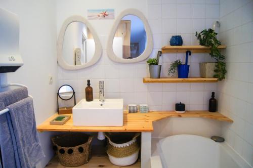 a bathroom with a sink and two mirrors at La Playa - 5 couchages climatisé in Romans-sur-Isère