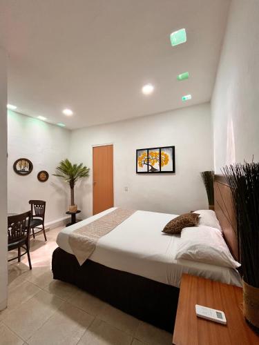 a bedroom with a large bed and a table at Adarax Playa Hermosa in Cancún