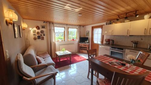 a kitchen and living room with a couch and a table at Ferienwohnung am Rebhang in Sasbachwalden