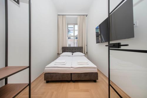 a bedroom with a bed and a flat screen tv at Slawkowska No 6 Residence in Krakow