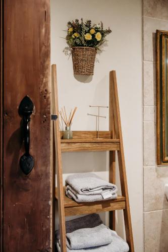a wooden ladder with towels and a basket of flowers at Staneve Cottage in Docking