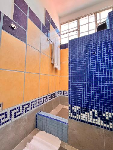 a bathroom with a shower with blue tiles on the wall at Adarax Playa Hermosa in Cancún