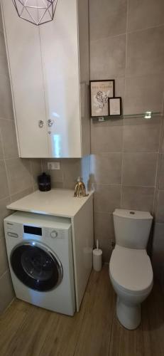 a bathroom with a toilet and a washing machine at Lilli's House in Kassiopi