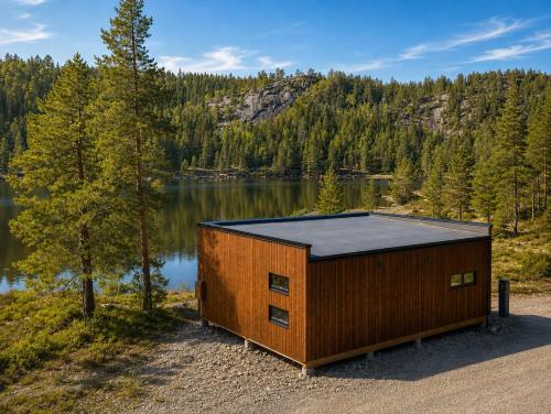 a small building on the side of a lake at Peaceful lakefront cabin in Tjaldal