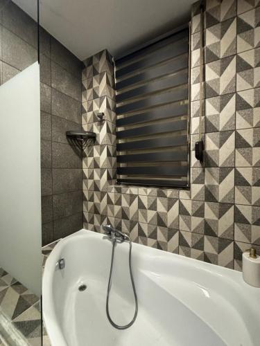 a white bath tub in a bathroom with a window at Panorama Apartament in Poznań