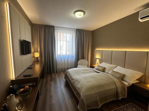 a hotel room with a bed and a television at Hotel Jelen in Hlohovec