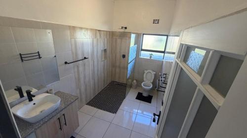 a small bathroom with a sink and a toilet at SiwelaNest in Mbabane