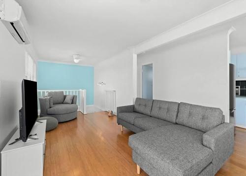 a living room with a couch and a tv at Mindil Arch Walk to 3 Beaches & River in Tomakin