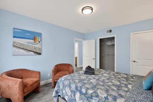 a bedroom with a bed and two chairs at Steps to Sand Updated Bouchee Beachy Condo Deck Parking in Brigantine