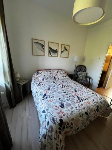 a bedroom with a bed with a floral bedspread at Guingamp studio with garden view in Guingamp