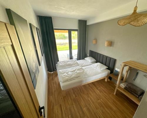 a bedroom with two beds in a room with a window at Osada Sielankowo - Kopiec in Żałe