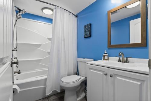 a bathroom with a toilet and a sink and a mirror at Radiant Beach Block Condo Parking Patio in Brigantine