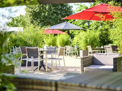 a group of chairs and tables with umbrellas at ibis Abbeville in Abbeville