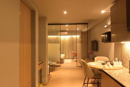 a kitchen and living room with a table and chairs at The Signature Suite in Raipur