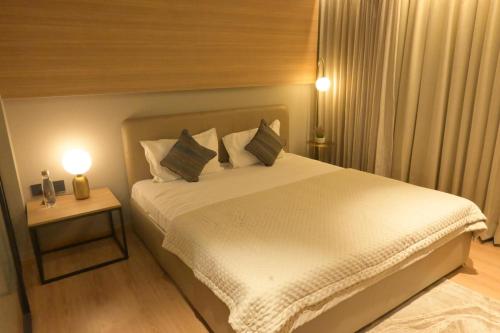 a bedroom with a large white bed with two lamps at The Signature Suite in Raipur