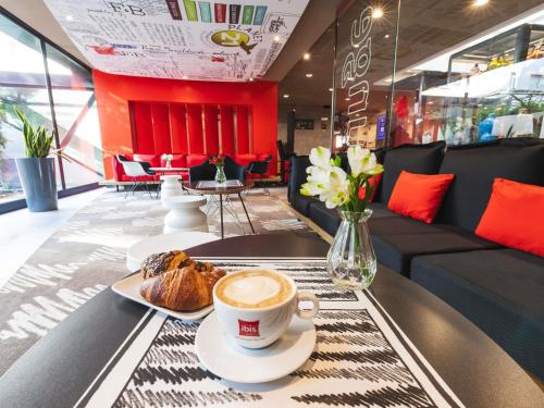 a cup of coffee and bread on a table in a restaurant at Ibis Milano Centro in Milan