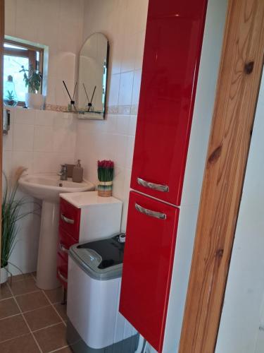 a red cabinet in a bathroom with a sink at Villa Aili in Pärnu