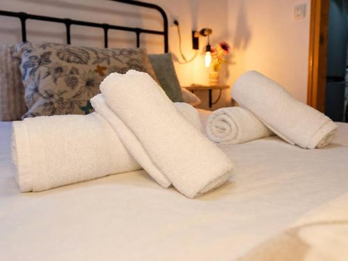 two rolls of white towels sitting on a bed at Cazorla Centro|Cómodo apartamento de 2 dormitorios in Cazorla