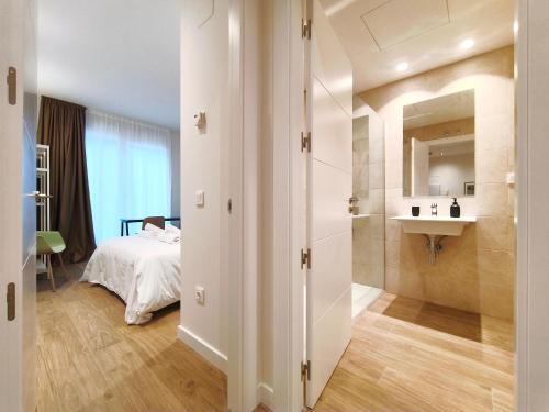 a bathroom with a bed and a sink in a room at Apartamentos Mantería Lacort, Valladolid in Valladolid