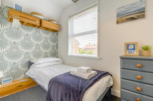 a small bedroom with a bed and a dresser at 2 Bed in Holt oc-2231 in Holt