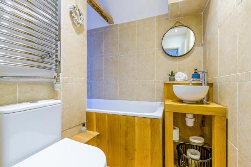 a bathroom with a tub and a sink and a mirror at 2 Bed in Holt oc-2231 in Holt
