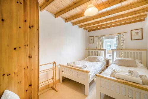 two twin beds in a room with wooden ceilings at 3 Bed in Askrigg oc-ds926 in Askrigg