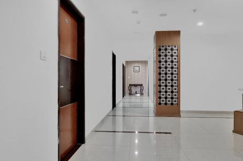 a hallway of a building with white walls and wooden doors at Super Hotel O Rudra Grand in Hyderabad