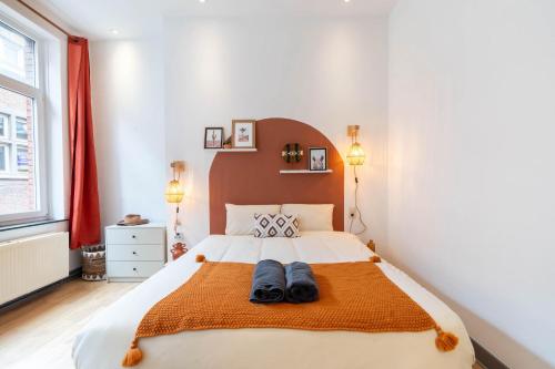 a bedroom with a large bed with two pairs of shoes on it at Le West - Dinant Centre in Dinant