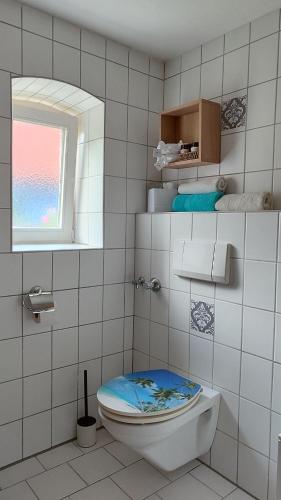 a bathroom with a toilet with a blue lid at Vacation apartment Stüble in Aichstetten
