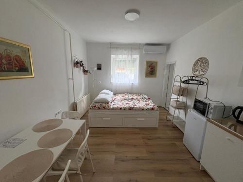 a small bedroom with a bed and a table at Haromfa Apartman in Háromfa