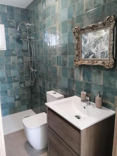 a bathroom with a sink and a toilet and a mirror at Finca Laxuan in Cádiz