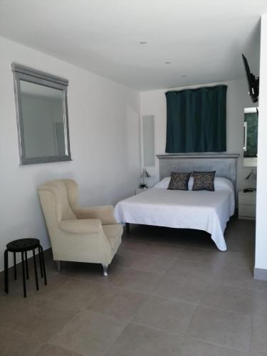 a bedroom with a bed and a chair at Finca Laxuan in Cádiz