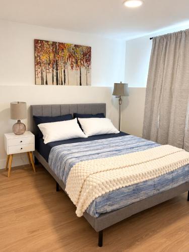 a bedroom with a bed and a painting on the wall at Modern Riverview Suite Near Downtown Moncton in Riverview